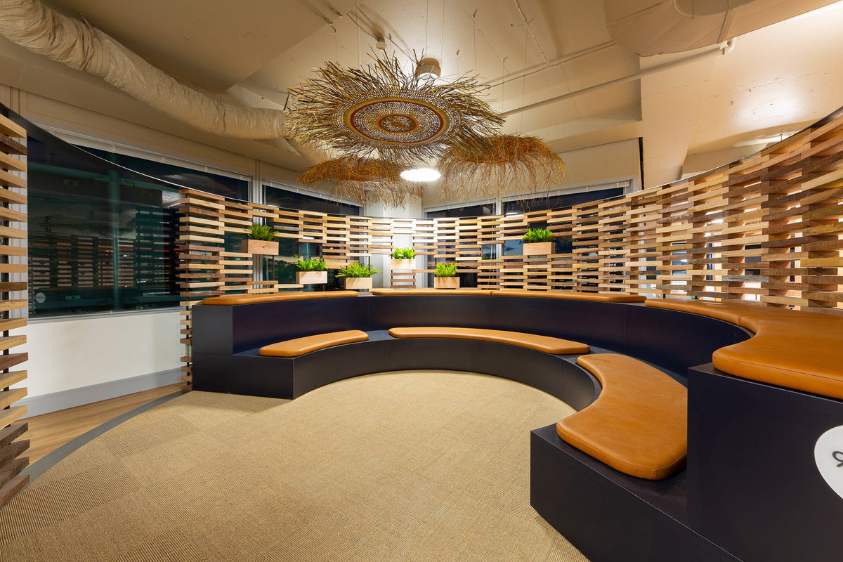 Curved timber gathering space with circular seating at AMA Sirius, Canberra