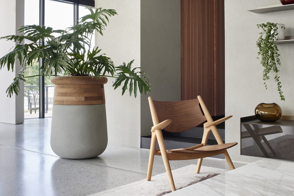 Indigenus Soma planter with timber collar beside a lounge chair